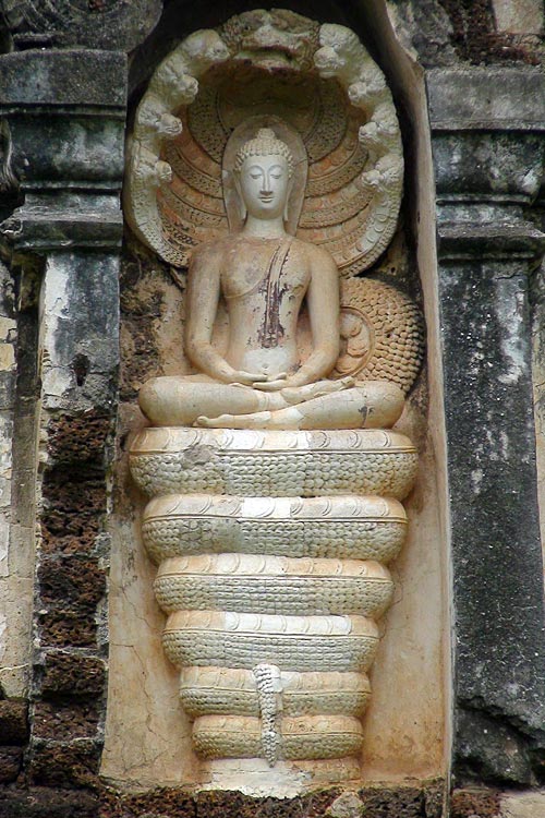 Sitting Buddha in meditation posture, sitting on coils of a serpent, and covered by its nine heads. Wat Chedi Jet Thaew, Si Satchanalai
