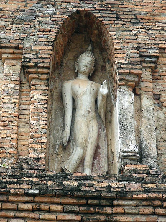 Walking Buddha Image in a niche at Wat Mahathat, Sukhothai.