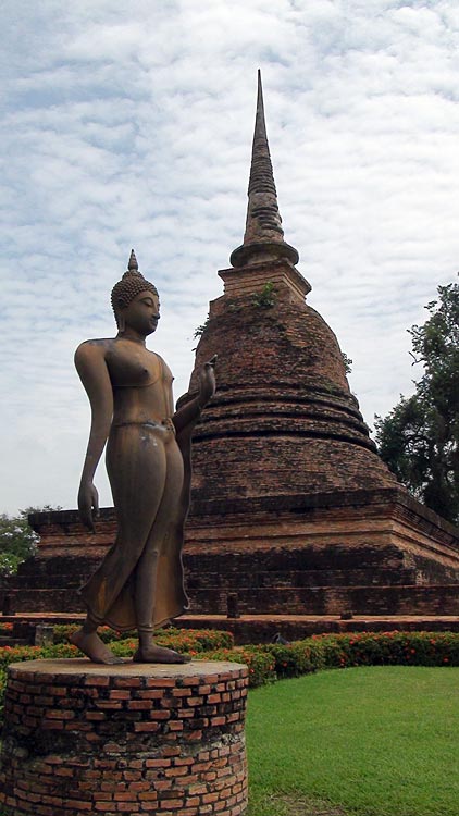 Another view of the Walking Buddha with the main Stupa, at Wat Sa Si, Sukhothai.